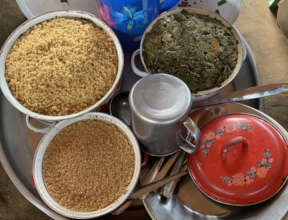 Refugees prepare a meal of tree leaves with maize