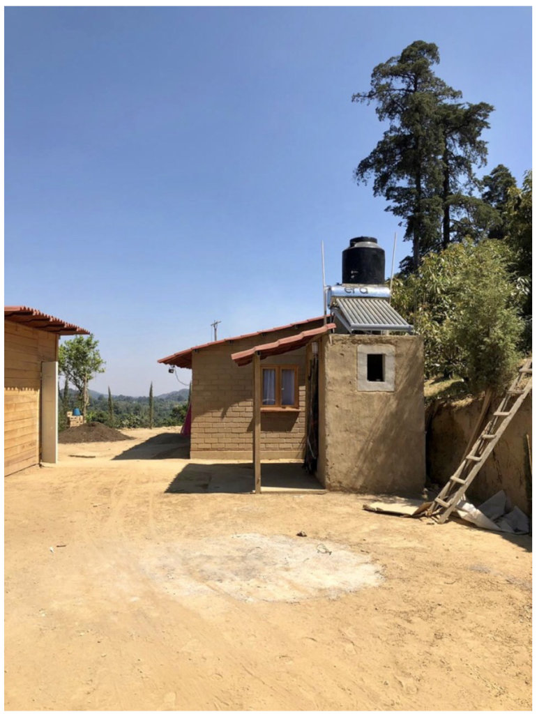 The bathroom is next to the house and the kitchen.