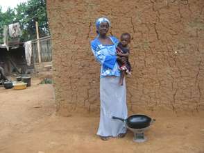Afia with her daughter, coal pot and frying pan.