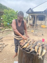Ruth cooks fish for sale in her shop.