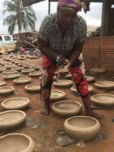 Felicia working with her pots.