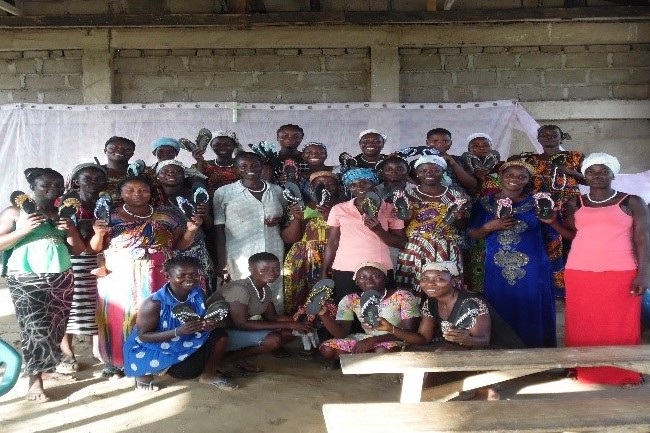 group of women show their newly-made beaded sandals