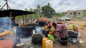 Women manually processing palm oil.
