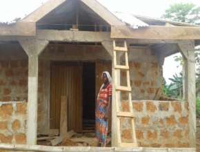 Saudatu with her store during construction
