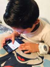 Child answering activity sheet via cellphone.