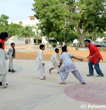 A volunteer teaches the students basketball