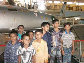 Children pose by a jet at the museum