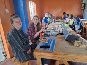 Women and volunteers having lunch during Jamhuri