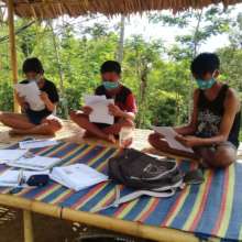 Students taking exam at home supervised by teacher