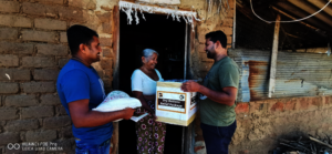 Our team handing relief to a grateful elderly lady