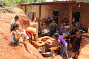 Women construct wood-saving stoves in community