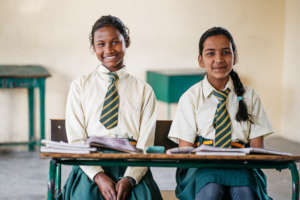 Santoshi and Cynthia at their school desks