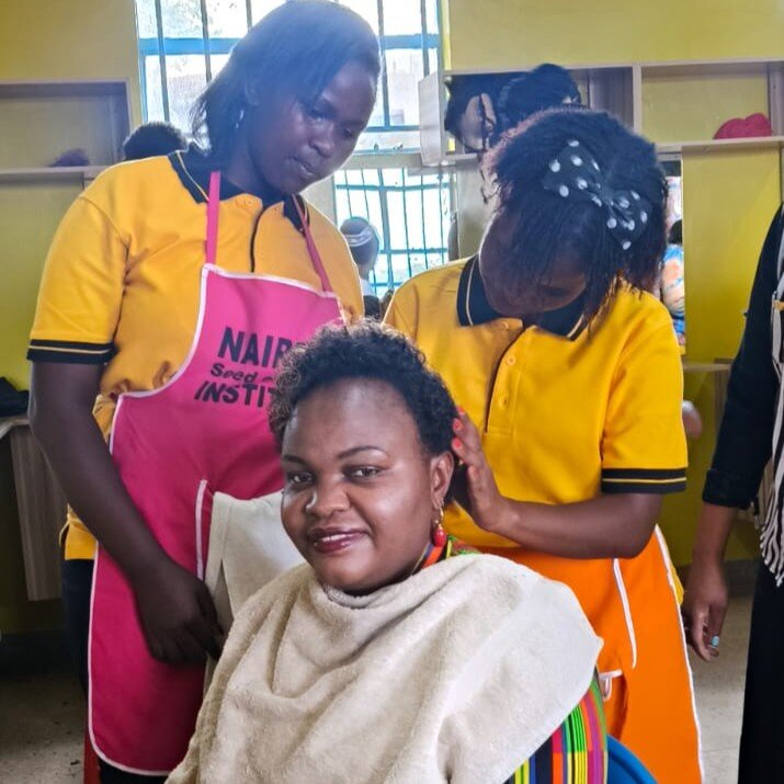 Exec Director, Mary, has makeup done by students
