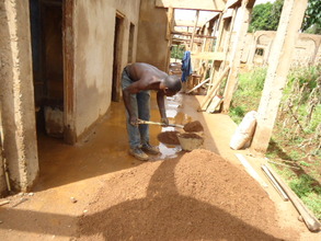 Bricklayer measuring sand to be mixed with cement
