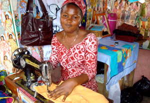 Nsawam loan client, Gifty, sews school uniforms