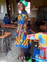Tailoring trainee checking on a dress she made