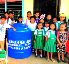 Students gathered around AAI clean water tank