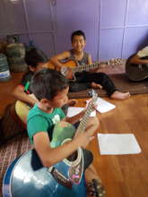 Playing the guitar, taught at School+Plus