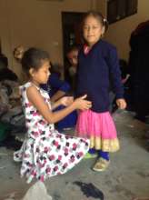 sister helps her sibling try a new school sweater
