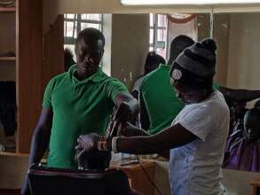 An instructor showing haircut skills to a student