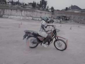 A lady practicing how to ride a motorcycle