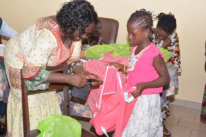 Child receiving backpack and school supplies.
