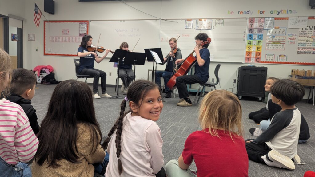 A JOY kindergartener enjoys a string quartet