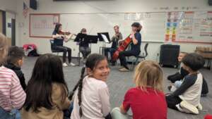 A JOY kindergartener enjoys a string quartet