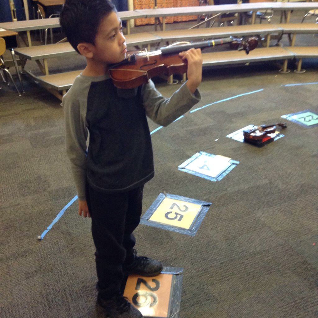 JOY is a kindergartener playing the violin.