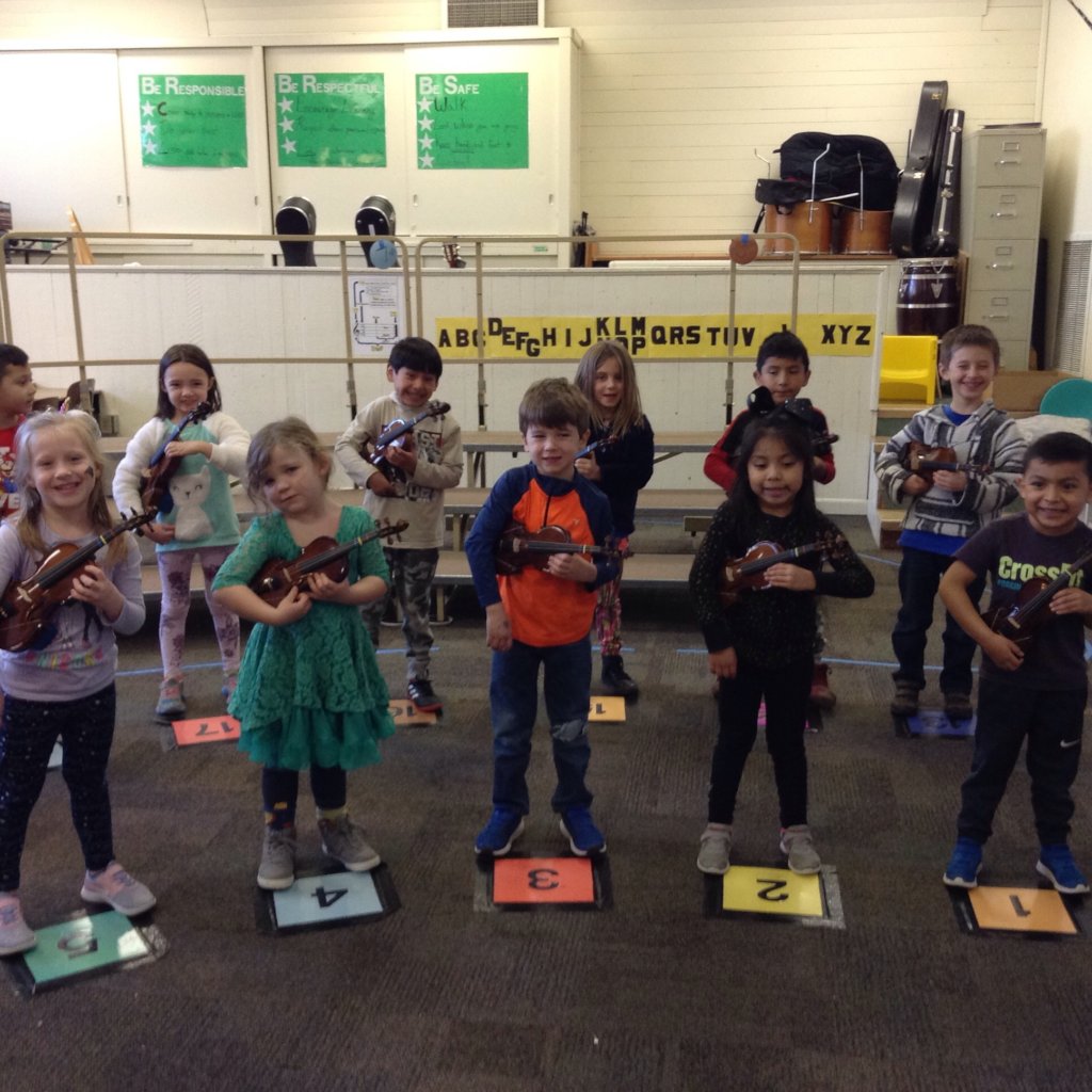 JOY is a kindergartener playing the violin.