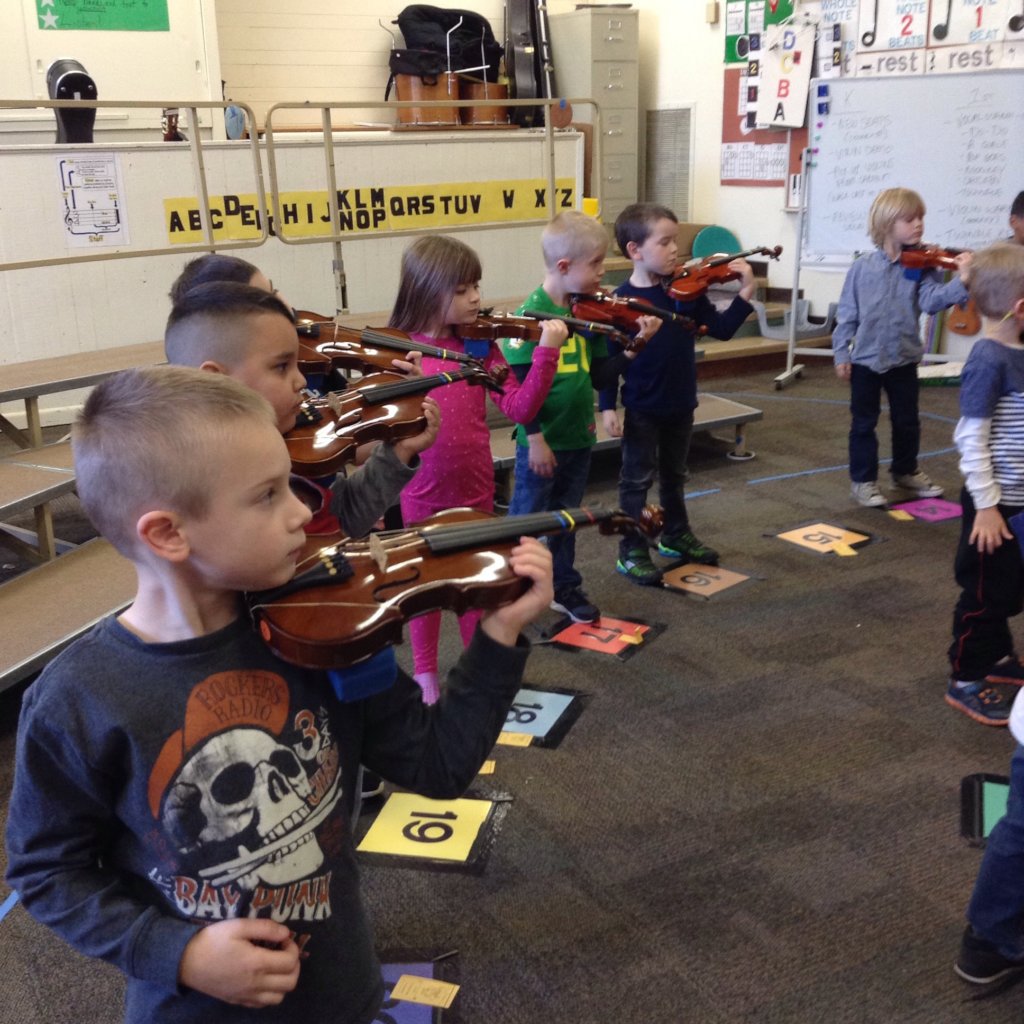 JOY is a kindergartener playing the violin.