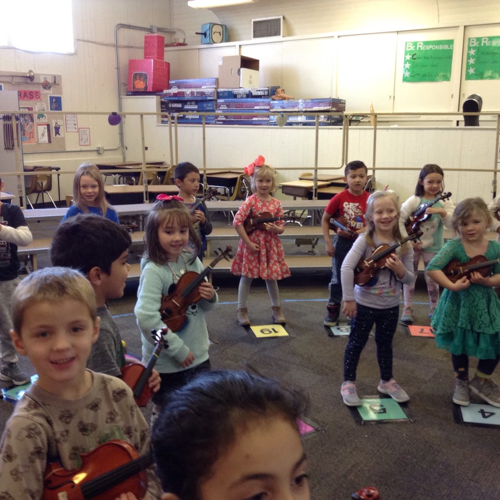 JOY is a kindergartener playing the violin.