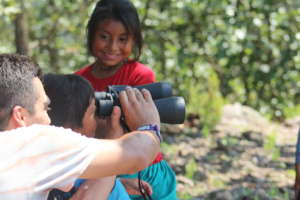 Wixaritari girl learn to use  binoculars