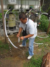 Deddy collecting a water sample for testing