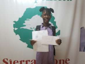 Joy with her BECE result & prize