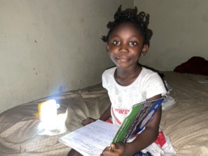 Chrisata studying at night with her solar light