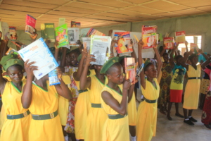 Girls holding the books we helped to provide