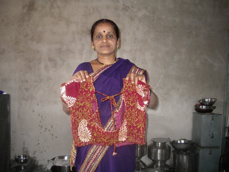 Holding a blouse that she has sewn