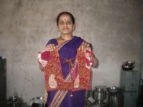 Holding a blouse that she has sewn