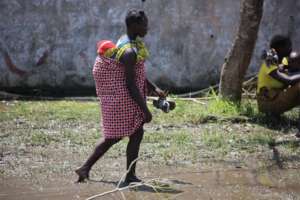 Carrying a child across the flooded areas.
