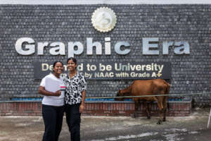 Finally at Graphic Era! With cow drinking behind.