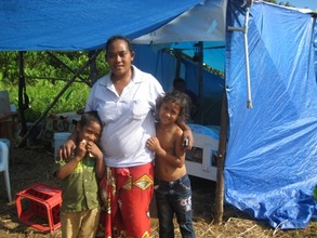 Ruta Sao and her two remaining children outside tarp shelter