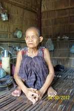 Grandmother, 85, sits inside the one room house.
