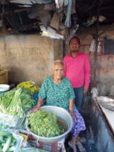 R, 26 with his grandmother at their market stall