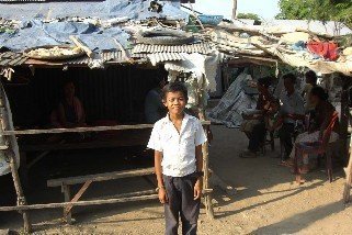 Kry,age 10, outside his home in Anlung Kgang