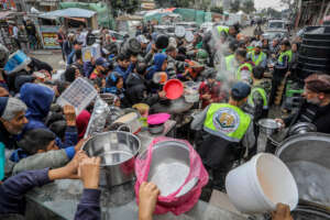 Palestinians wait for a hot meal in Rafah/ Flash90