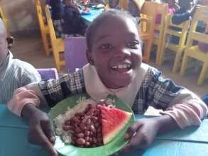 A happy child enjoys her meal at Seed School