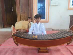 Lya performs Khmer traditional music at a village