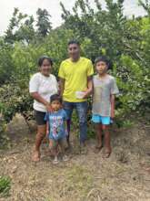 A family stands among their maturing citrus trees