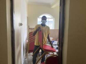 A student cleaning chairs after school painting